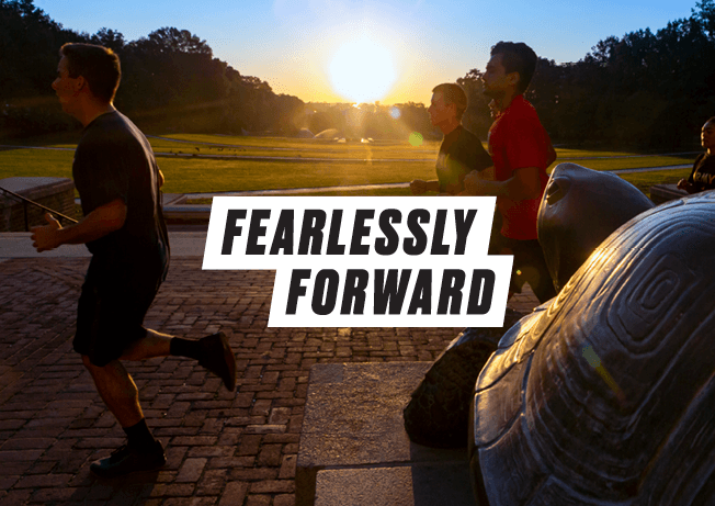 Fearlessly Forward | people running by Testudo statue